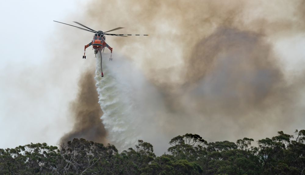 Helicopter dumping water on fire