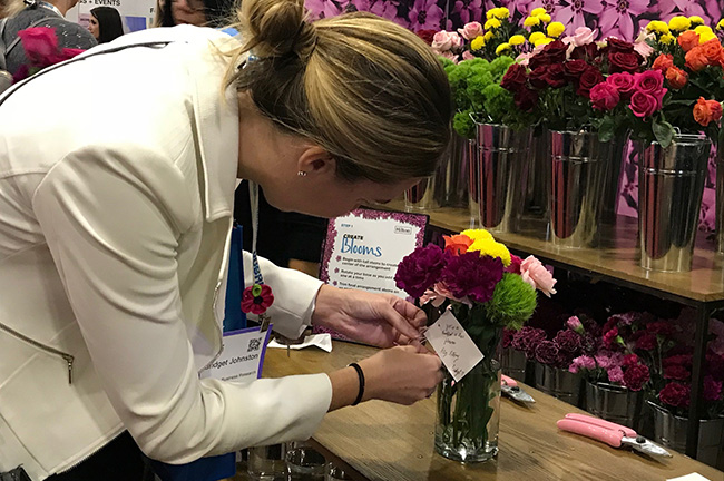 IMEX America Attendee Creating a Bouquet at the Repeat Roses Booth